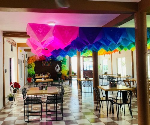 Interior acogedor de un restaurante na' juanita con mesas elegantemente dispuestas, iluminación cálida y ambiente familiar